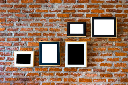 Brick wall decorated with photo frames left blank in black and whiteの写真素材
