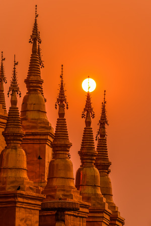 Group of pagodas during sunrise in Buddhist temple of Thailandの写真素材