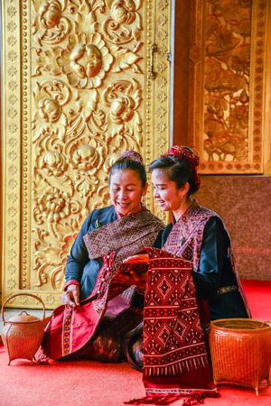 NAKORN PHANOM, THAILAND - FEBRUARY 14, 2015: Tourist senior ladies visit and join Thai northeastern Phutai world event day looking to local woven fabric in Buddhist church in Renunakorn of Nakorn Phanom, Thailandのeditorial素材