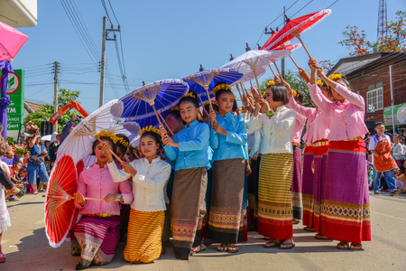 CHIANGMAI, THAILAND - JANUARY 25, 2015: Indigenous little girls with traditional costume holding  umbrellas and dancing in traditional style in parade of 22nd Traditional Skirt Fabric and The Indigenous Product and Culture Festival in Mae Chaem, Chiangmaiのeditorial素材