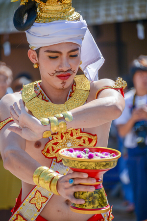 CHIANGMAI, THAILAND - JANUARY 25, 2015: Indigenous dancer man with traditional costume holding tray with pedestal of flower dancing in parade of 22nd Traditional Skirt Fabric and The Indigenous Product and Culture Festival in Mae Chaem, Chiangmai, Thailanのeditorial素材