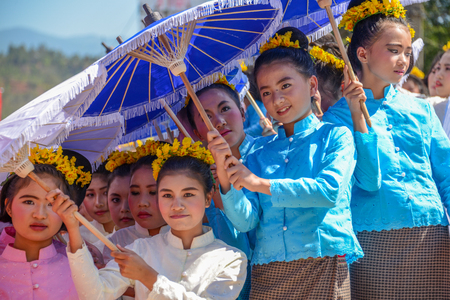CHIANGMAI, THAILAND - JANUARY 25, 2015: Indigenous little girls with traditional costume holding  umbrellas and dancing in traditional style in parade of 22nd Traditional Skirt Fabric and The Indigenous Product and Culture Festival in Mae Chaem, Chiangmaiのeditorial素材