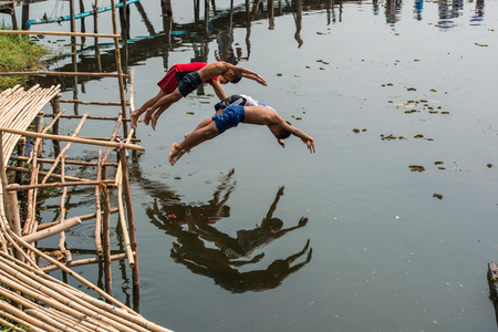 Mahasarakham, Thailand - February 22, 2016: Rural children lifestyle having fun by jumping  into river together in Mahasarakham, Thailand.のeditorial素材