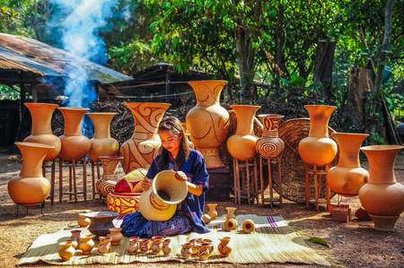 Udonthani, Thailand - December 10, 2012: Beautiful artist woman painting on earthenware which is rural small enterprise in Udonthani, Thailandのeditorial素材