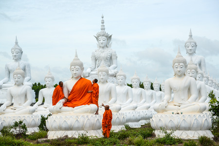 Sa Kaeo, Thailand - July 14, 2013: Monks dressing one of White Buddha Image with robes in Buddha Park of Sa Kaeo, Thailandのeditorial素材