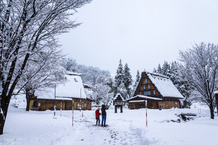 Gifu, Japan - December 12, 2013: Tourists taking photos in Shirakawago, world heritage village, the tourist destination, in winter with snow falling in Gifu, Japanのeditorial素材