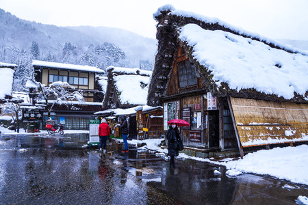 Gifu, Japan - December 12, 2013: Tourists walking and sightseeing in Shirakawago,  the tourist destination, in winter with snow falling in Gifu, Japanのeditorial素材
