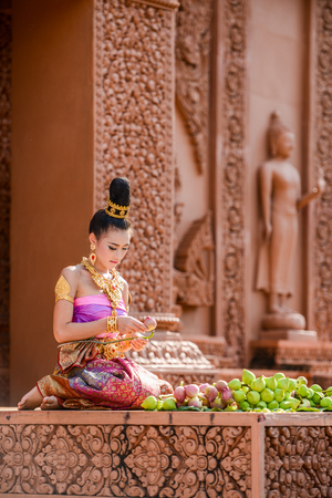 Kanchanaburi, Thailand - December 14, 2014: Woman with traditional dresses folding lotus petal for being used to worship Buddha image in Buddhist church in Kanchanaburi, Thailandのeditorial素材