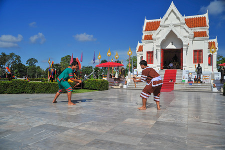 Phitsanulok, Thailand - April 8, 2011: Two men in traditional dress holidng sword demonstrating Thai traditional fencing outdoor to tourists in front of King Naresuan shrine in Phitsanulok, Thailandのeditorial素材