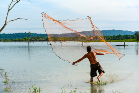 Chachoengsao, Thailand - December 8, 2011, Fisherman  casting traditional fishing net to fish in rural swamp in Chachoengsao, Thailandのeditorial素材