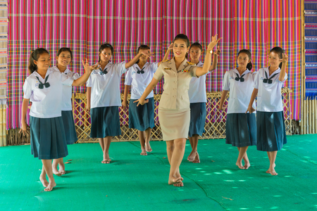 Khonkaen, Thailand - December 19, 2015: Beautiful teacher in uniform teaching her students in traditional northeastern style dancing in secondary school in Khonkaen, Thailandのeditorial素材