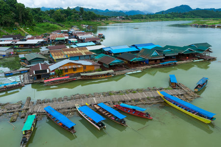 Rural village on river with wooden and bamboo port for travelling boat for tourists in Kanchanaburi,...