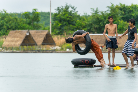 Uttaradit, Thailand - August 6, 2017: Group of teenage boys diving into water in river close to resort in rural of Uttaradit, Thailandのeditorial素材