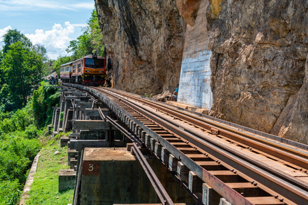 Kanchanaburi, Thailand - May 13, 2018: Vintage diesel engine train transporting tourists and running out of station on historic railway in Kanchanaburi, Thailandのeditorial素材