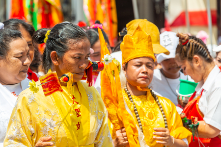 Phang Nga, Thailand - October 14, 2018: Woman demonstrating sharp steel run through the mouth in vegetarian festival parade in Phang Nga, Thailandのeditorial素材