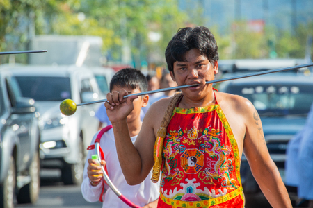 Phang Nga, Thailand - October 15, 2018: Man demonstrating sharp steel run through the mouth in vegetarian festival parade in Phang Nga, Thailandのeditorial素材