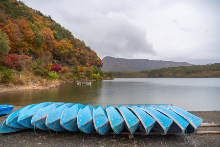View of lake and a row of boat on shore in cloudy day in rural of Yamanashi, Japanの写真素材