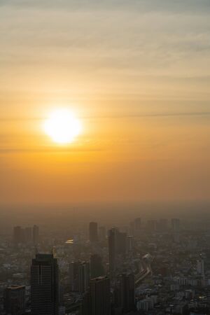 Beautiful sunset in the city of Bangkok  where is the capital city of Thailand covering with air pollution creating unclear scene and unhealthy.の写真素材