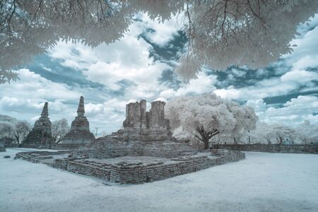 Ruined ancient Buddhist temple and pagoda in Ayutthaya historical park, Thailand in infrared photographyの写真素材