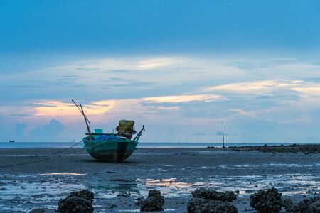 Fishing boat parking on shore during morning in sunny dayの写真素材