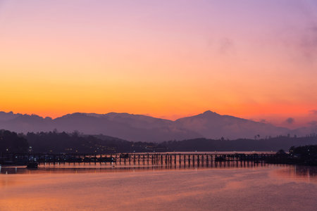 Beautiful view of Mon wooden bridge in fog environment in early morning during sunrise in Sangklaburi, Kanchanaburi, Thailandの写真素材