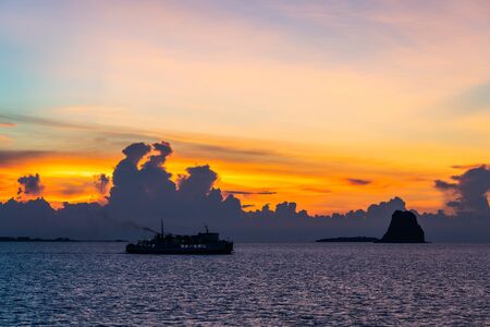 Silhouette unidentified ferry ship running sea during beautiful sunset