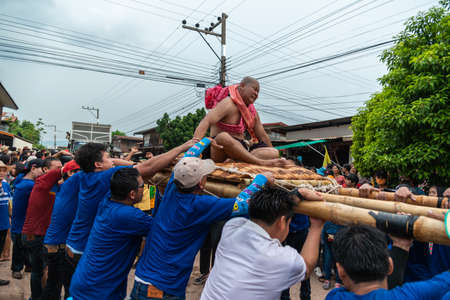 Chaiyaphum, Thailand - May 12, 2019: Parade of ancient pre-ordination of Buddhist which pre-monk on bamboo litter shaken severely before ordination in Buddhsit temple in Chaiyaphum, Thailandのeditorial素材