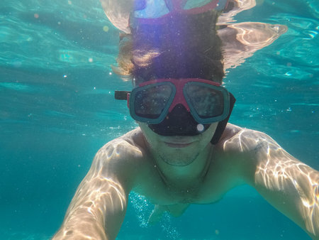 The man with the underwater mask is engaged in diving