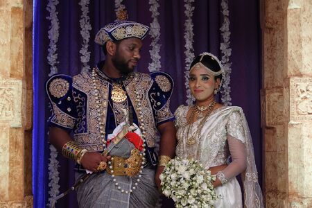 Wadduwa, Sri Lanka - May 11, 2018: Beautiful wedding ceremony in Sri Lanka. Newlyweds in traditional costumes stand under the arch. Wedding ceremony location with bride and groomのeditorial素材