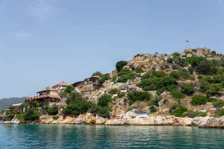 Kalekoy, Simena , Turkey - June 03, 2019: Kalekoy village with stone built houses and castle on top of hill in Uchagiz bay in Turkey near sunken city of Kekovaのeditorial素材
