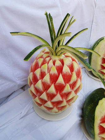 Large fresh watermelon with carved decorations on the counter. Decorative watermelon carving. fruit cutting artの写真素材