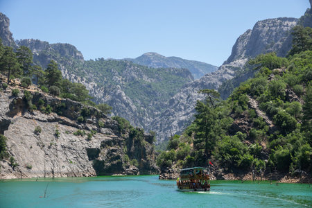 Manavgat, Turkey - June 05, 2019: People on a tourist yacht float on the lake among the mountain cliffs of Green canyon. Landscape of Green canyon, Manavgat, Antalya, Turkeyのeditorial素材