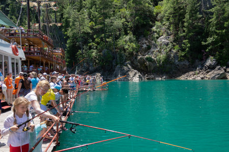 Manavgat, Turkey - June 05, 2019: Tourists fishing in the lake near the tourist yacht among mountain cliffs in the Green Canyonのeditorial素材