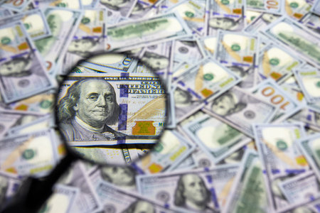 One hundred dollar banknote under magnifying glass. USA national currency. Banking and financial concept. Blurred backgroundの写真素材