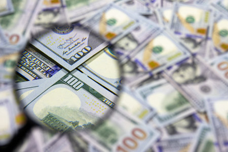 One hundred dollar banknote under magnifying glass. USA national currency. Banking and financial concept. Blurred backgroundの写真素材