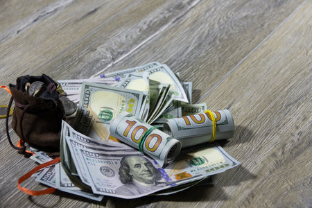 Closeup of one hundred dollar bills of American dollars and a money sack with different coins of the...