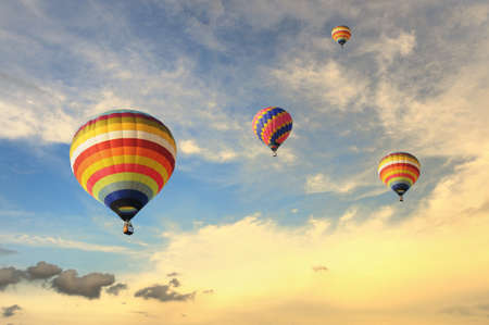 Colorful balloons rising up during sunsetの写真素材