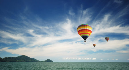 Beautiful hot air balloon over cloudy blue skyの写真素材