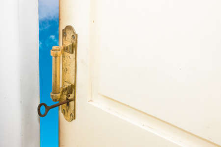 Better life, success, career development, challenge concepts represented by half-opened door to the blue skyの写真素材