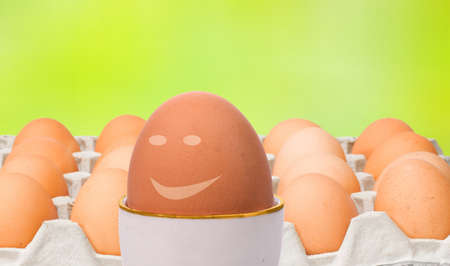 Leadership concept represented through eggs, one happy egg is out of crowd leading othersの写真素材