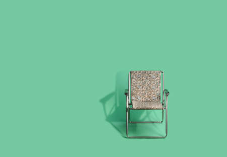 a folding chair from the seventies for the beach on a green backgroundの写真素材