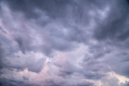 heavy rain clouds, cumulus clouds, move across the sky. soft pink and dark blue mix