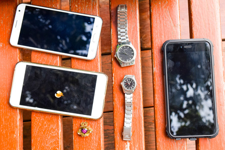 smartphone and watches on wooden backgroundの写真素材