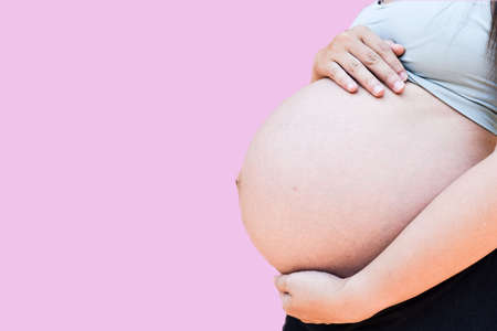 pregnant woman on pink backgroundの写真素材
