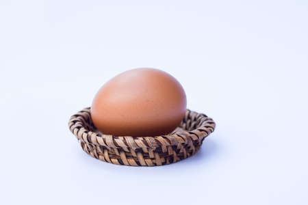 egg on wood basket isolated on white backgroundの写真素材