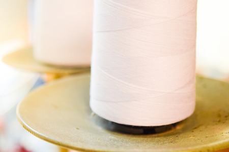 white sewing thread on sewing machineの写真素材