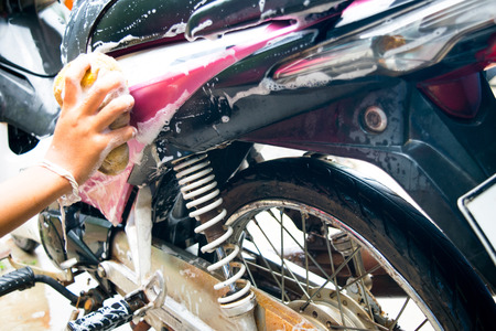 girl cleaning and Washing the Pink motorcycleの写真素材