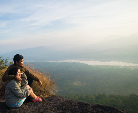 man and girl on a cliff with misty and foggy