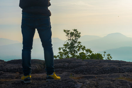 A young man on a cliff with misty and foggy