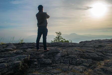 A young man on a cliff with misty and foggyの写真素材